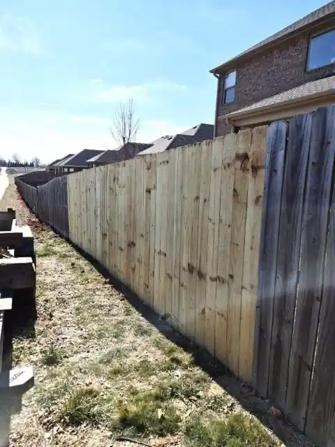 Pine board-to-board replacement run along a side yard after repair