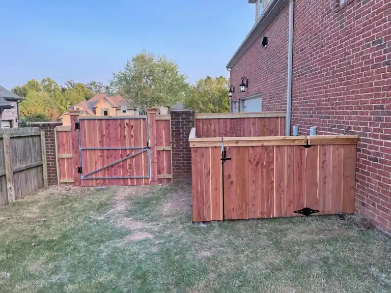 Fully braced cedar gate and enclosure against a brick house
