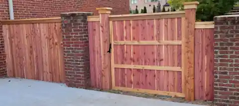 Cedar gate set into a brick column wall in Rogers, Arkansas