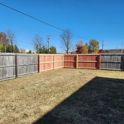 New cedar section installed between old grey fence panels
